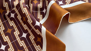 luxury silk scarf with geometric print in dark burgundy, golden brown and light beige tones with delicate hand-rolled edges