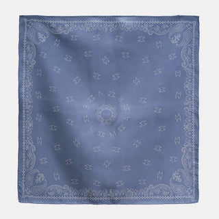 Dusty blue silk neckerchief with paisley border pattern, hand-rolled edges, and central MARVEL logo surrounded by decorative motifs