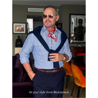 Stylish red silk neckerchief with paisley pattern paired with blue striped shirt and navy blazer, demonstrating elegant men's fashion styling