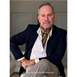Man wearing Amazon Toucan organic cotton-silk scarf with navy blue blazer and white shirt — classic, refined style showcasing sustainable fashion.