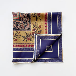 Indigo royal silk neckerchief with vintage floral design, featuring gold accents, red blooms, and decorative borders with hand-rolled edges