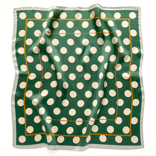 Square jade green silk scarf with cream polka dots, gold border accent and white trim edge, displayed flat showing subtle fabric texture.