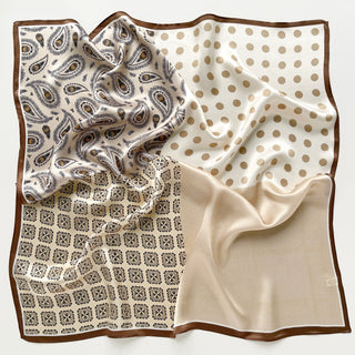 Square beige silk scarf with four distinct patterns: paisley print, polka dots, geometric tiles, and solid color, bordered with brown trim