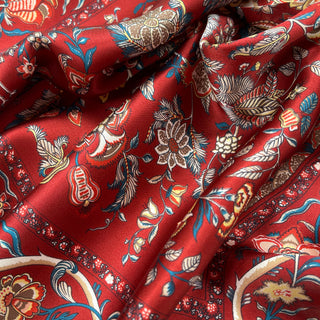 Luxurious red silk scarf with vintage floral pattern featuring ornate botanical designs in blue, white, and gold with decorative border detail
