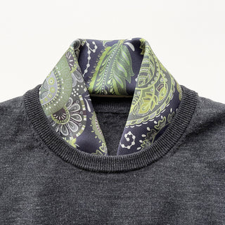 Forest green paisley silk scarf styled with gray sweater, showcasing intricate leaf patterns in deep navy and light green tones on luxurious twill fabric
