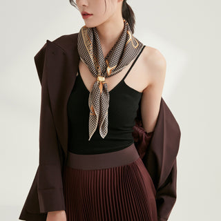 Luxury black and beige houndstooth silk scarf styled loosely around neck with equestrian accents, paired with black top and brown outfit
