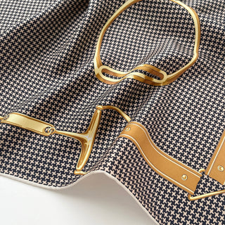 Luxury silk scarf with black and beige houndstooth pattern featuring gold equestrian-inspired design elements with hand-rolled edges