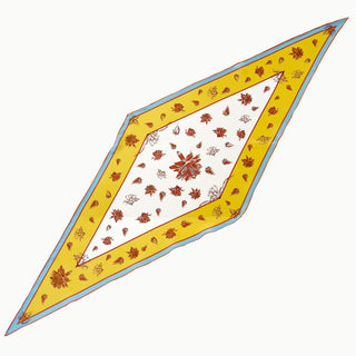 Diamond-shaped yellow floral silk scarf laid flat, featuring 100% silk crêpe de chine fabric with ivory center, yellow and blue border, and floral print.