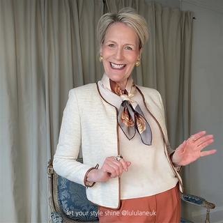 Woman wearing Berlin Rose silk scarf – 65cm vintage floral square bandana in sepia tones, styled over a white blazer.