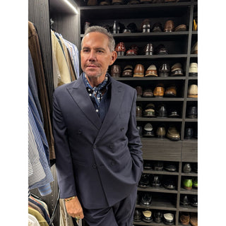Man wearing a navy patterned silk neckerchief by LuluLane styled with navy shirt and suit showcasing a refined, formal look.