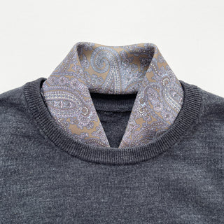 Men's silk neckerchief in taupe featuring paisley pattern tucked in a dark grey sweater.
