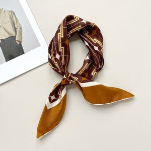 a luxury silk scarf featuring vintage charm 70s style patten in burgundy, tan and beige palette with hand-rolled hems, knotted as neckerchief or neck scarf