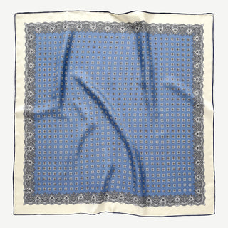Cornflower blue silk scarf featuring vintage micro-motifs and lace-inspired border, 65cm square design with hand-rolled hems.
