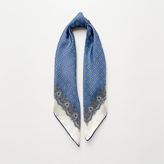Cornflower blue silk scarf featuring vintage micro-motifs and lace-inspired border, 65cm square design with hand-rolled hems.