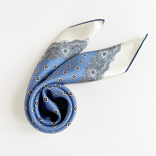 Cornflower blue silk scarf featuring vintage micro-motifs and lace-inspired border, 65cm square design with hand-rolled hems.