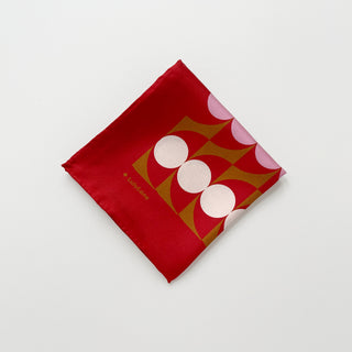 Folded geometric mid-century silk scarf by LuluLane with Bauhaus-inspired design in chocolate red, pink and brown tones showcasing the meticulous hand-rolled hems.