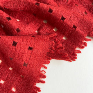 Close-up of a classic red pure cashmere scarf featuring open-knit jacquard by LuluLane