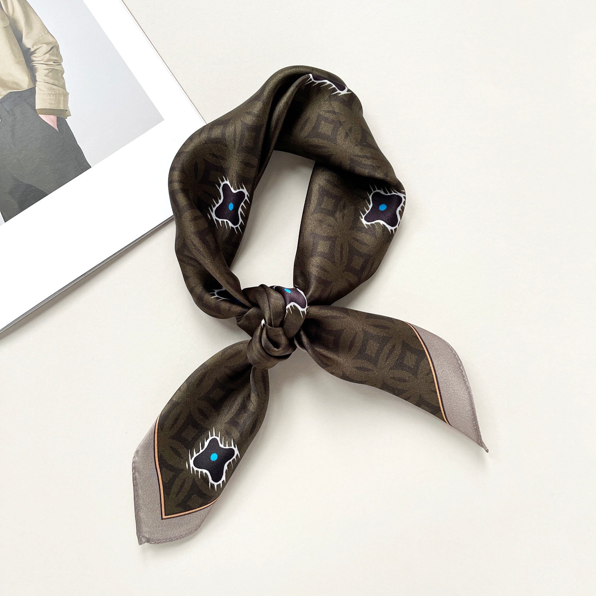 a dark olive green silk scarf neckerchief  featuring timeless print, knotted as a neckerchief 