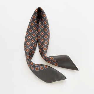 Lead grey silk square scarf by LuluLane with rust red four-petal flower motif, double-sided print and hand-rolled hems.
