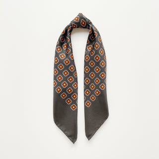 Lead grey silk square scarf by LuluLane with rust red four-petal flower motif, double-sided print and hand-rolled hems.