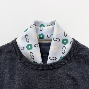 a turquoise square silk scarf with light grey base, featuring simplified floral print, tucked in a grey men's sweater