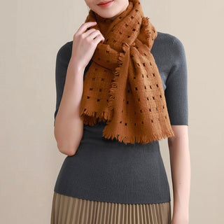 Woman wearing a mustard cashmere scarf by LuluLane in grey knitted top and beige pleated skirt.