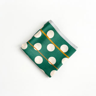 Square jade green silk scarf with cream polka dots and thin gold stripes, folded neatly against white background