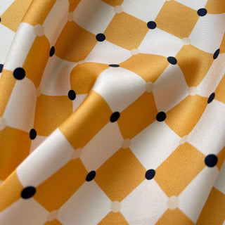 Close-up of a unisex silk scarf 65cm in chess board pattern, golden squash yellow and navy, double-sided print, hand-rolled hems by LuluLane.