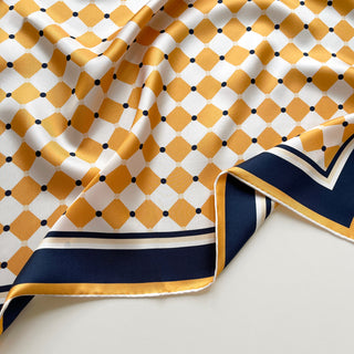silk scarf detail showing chess board pattern in golden squash and navy, smooth silk texture, double-sided print and hand-rolled hem by LuluLane.