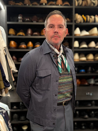 Teal green floral silk scarf elegantly styled with a grey jacket, showcasing versatile and finish touch for men's polished style