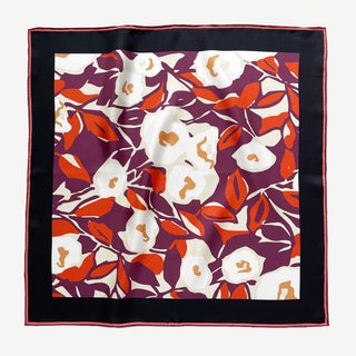 Silk bandana scarf by LuluLane with burgundy background, cream white floral print, and orangey red leaves, framed by black border with hand-rolled edges.