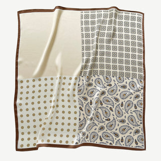 Beige silk scarf by LuluLane with intricate black paisley pattern on one side, solid cream colour on the other, featuring elegant brown border trim.