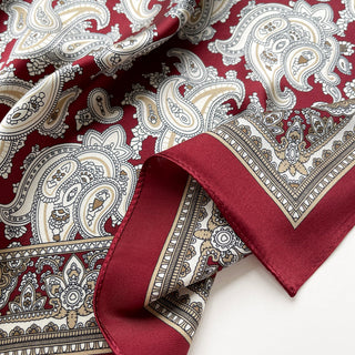 Close-up of dark red silk square neckerchief by LuluLane featuring intricate beige paisley patterns and geometric border details