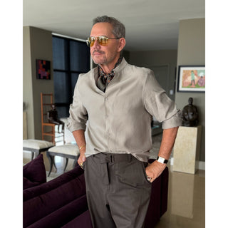 Man wearing a lead grey silk neckerchief with rust red four-petal flower motif showcasing a sharp and refined look.