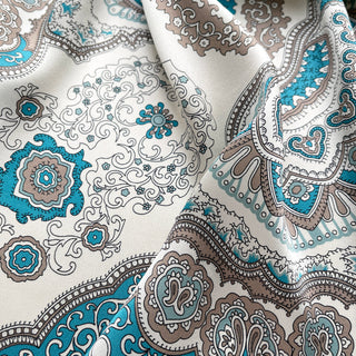 Elegant silk scarf with vintage baroque pattern in turquoise blue and taupe on cream background, featuring ornate medallions and decorative border