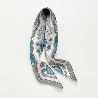 Elegant silk scarf with vintage baroque pattern in turquoise blue and taupe on cream background, featuring ornate medallions and decorative border