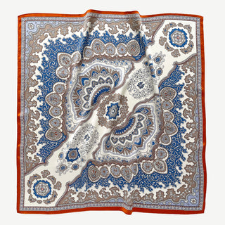 Square silk scarf with blue and orange baroque pattern featuring intricate paisley designs and medallions on cream background with vibrant border