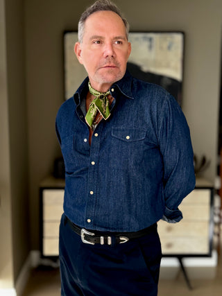 Styling example: green men's silk neckerchief with beige paisley pattern worn with blue denim shirt in indoor setting