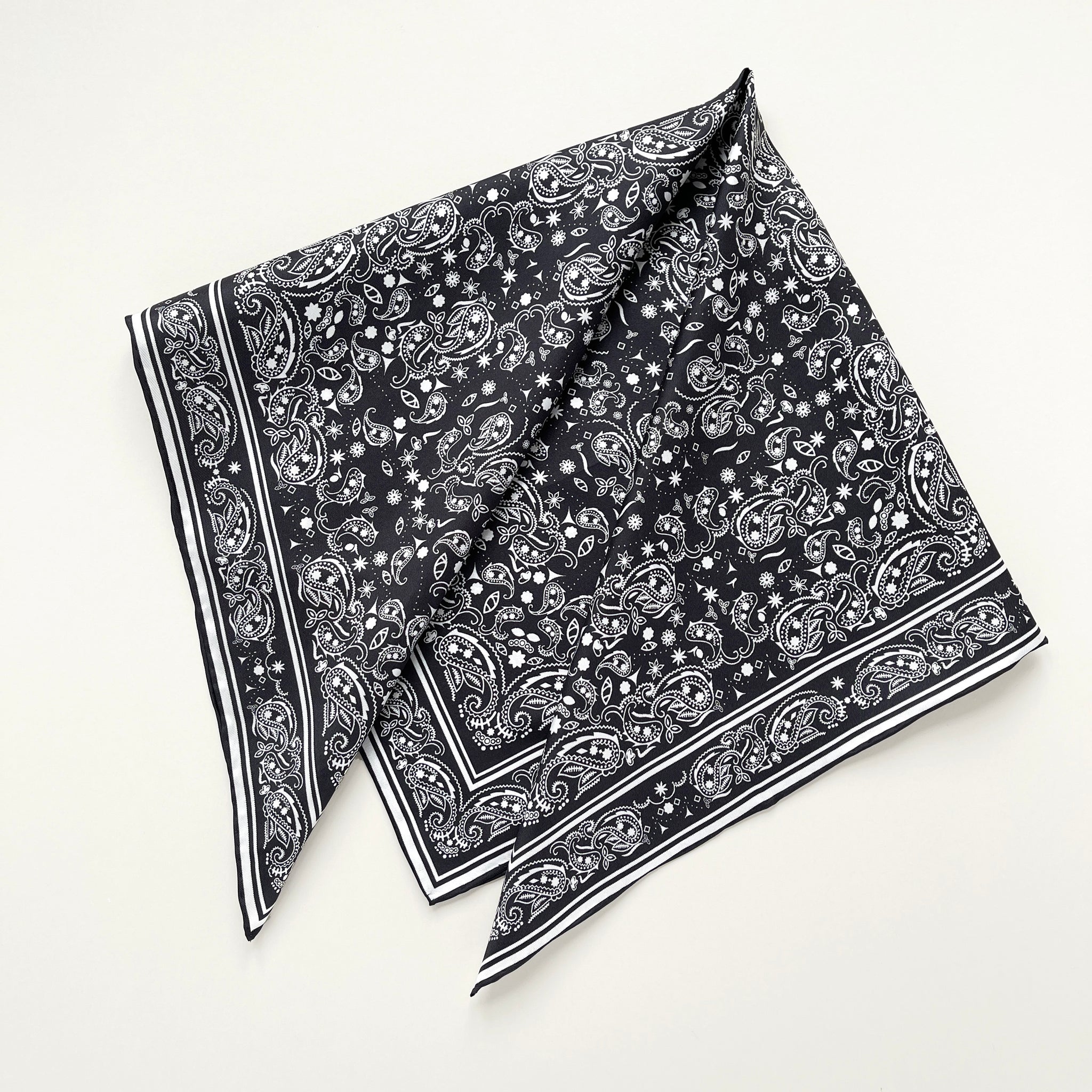 a black and white silk scarf featuring bohemian paisley print with hand-rolled edges