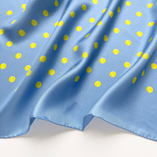 Close-up of women’s sky blue tennis polka dot silk scarf, square bandana inspired by British summer tennis courts