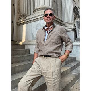 Man wearing a burgundy Bauhaus silk neckerchief with a striped linen shirt, styled as a timeless men's smart casual accessory.