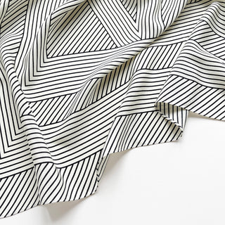 Close-up of women’s black and white geometric silk scarf in 90x90cm square design with subtle LOVE lettering and minimalist stripe pattern