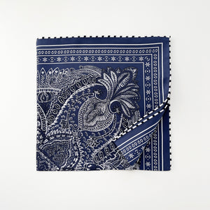 a navy blue bandana silk scarf featuring white and black symmetric pattern with striped hand-rolled edges