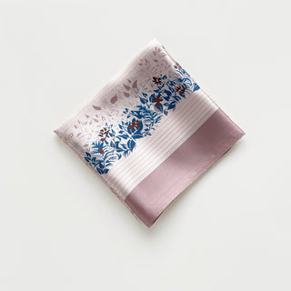 Blush pink silk scarf with vibrant blue and burgundy leaf pattern, showcasing the fabric's natural sheen and delicate texture in elegant folds.