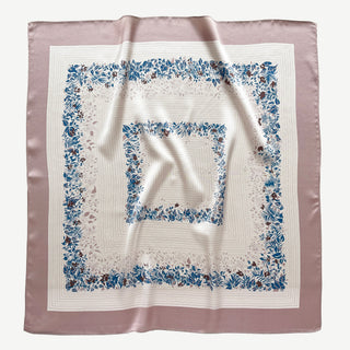 Square silk scarf with blush pink border and cream center featuring blue and burgundy leaf pattern. Elegant 65cm bandana displayed with gentle folds showing natural sheen.
