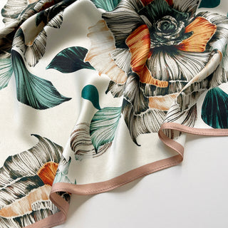 Close-up of women's floral silk scarf with botanical flower print in ivory peach and teal, 53cm square silk bandana