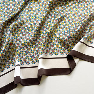 close-up of men's silk neckerchief featuring heritage geometric print and brown edge