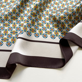close-up of men's silk neckerchief featuring heritage geometric print and brown edge