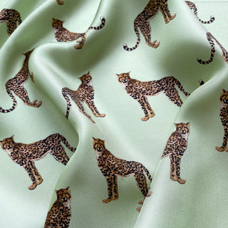 Close-up of mint green silk scarf with brown and black leopard print pattern