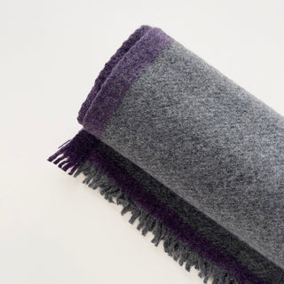 Close-up of the grey and purple short fringed ends on a 100% cashmere scarf.
